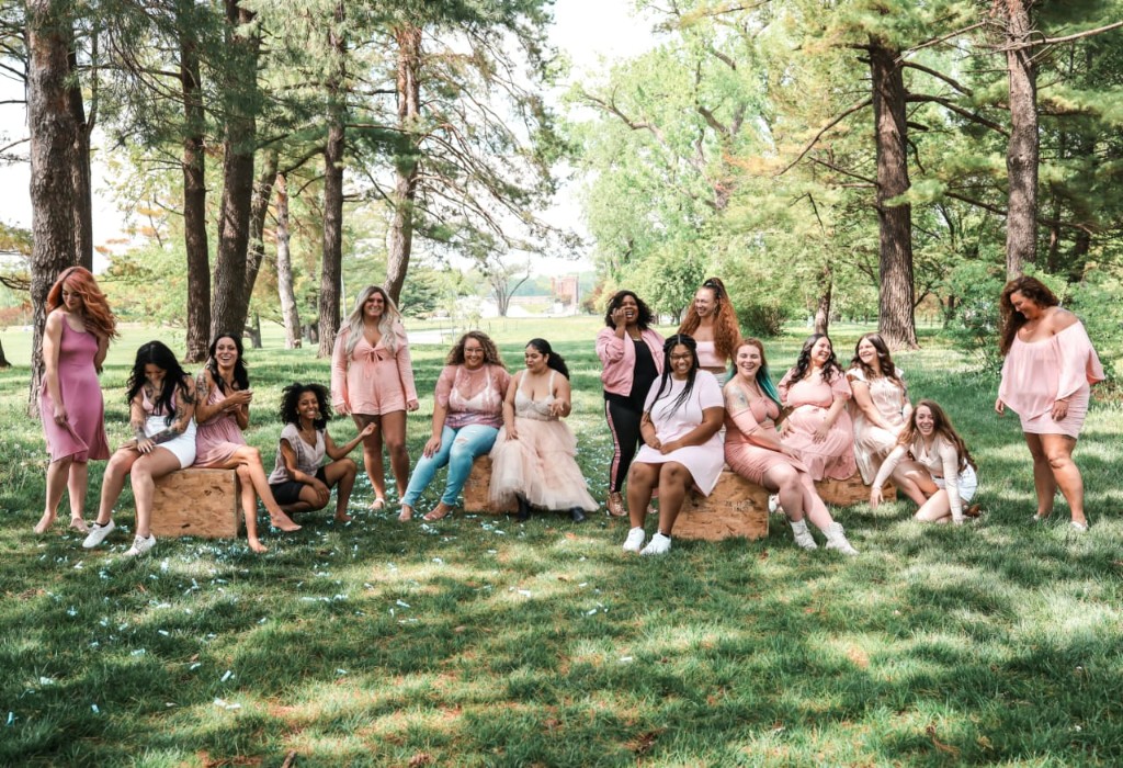 Diverse group of women in pink gathered together outdoors