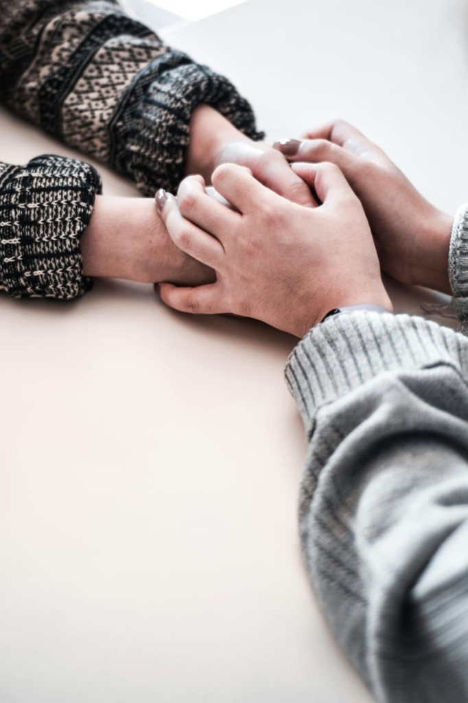 Two women holding hands in a moment of support and connection